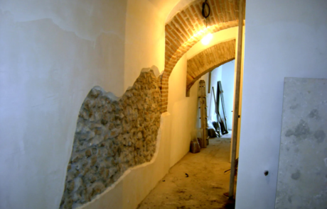 Corridoio ristrutturato con arco in pietra lasciato a vista