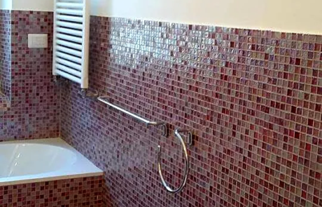 Bagno ristrutturato con rivestimento a mosaico e sanitari
