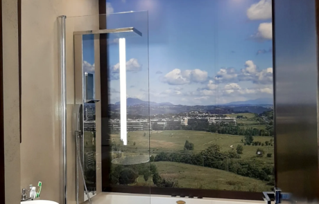 Bagno ristrutturato con vasca, box doccia in vetro e parete con carta da parati panoramica