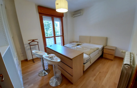 Camera da letto ristrutturata con parquet e porta finestra
