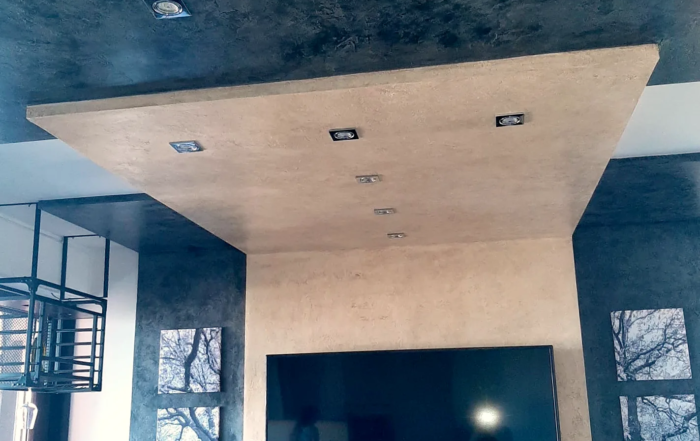 Controsoffitto sospeso con faretti sopra la parete TV in un soggiorno ristrutturato