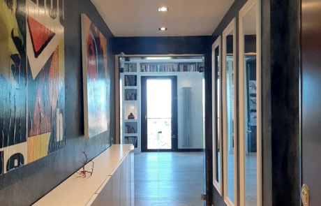 Corridoio ristrutturato con parquet, armadi a muro a specchio e faretti a incasso