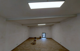 Dopo i lavori: interno del garage trasformato in locale con pavimento nuovo e luci a pannello