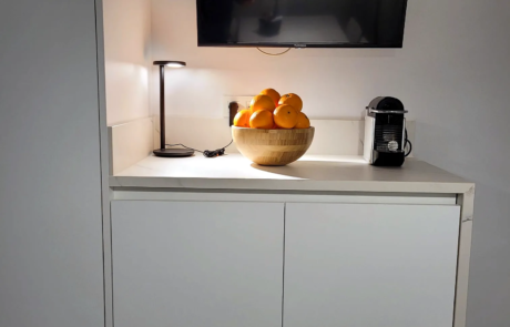 Mobile basso bianco con TV a parete in un ambiente ristrutturato