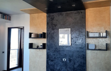 Parete decorativa in soggiorno con finitura materica scura e mensole
