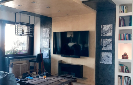 Soggiorno ristrutturato con controsoffitto decorativo, libreria in cartongesso e parete TV